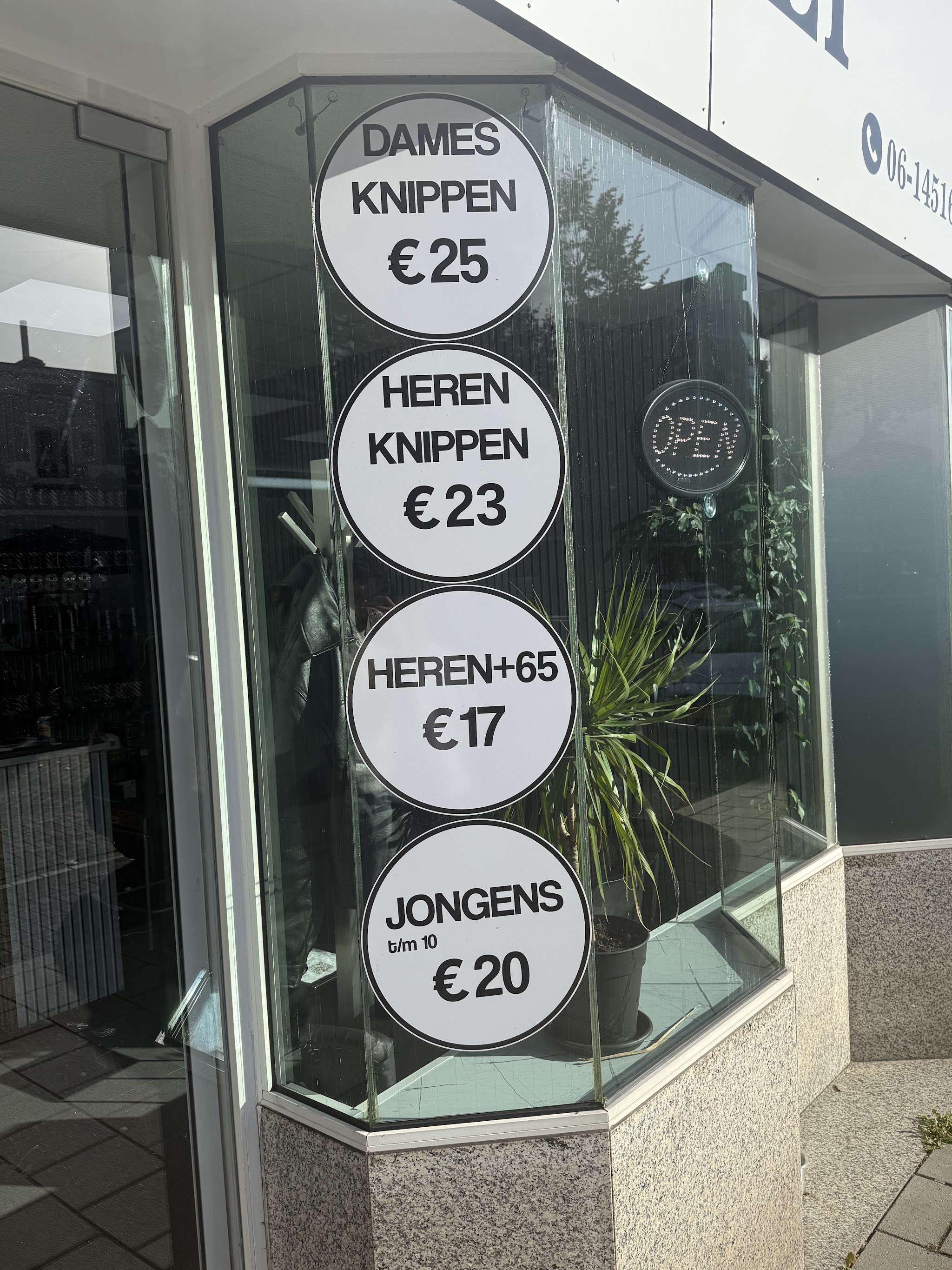 De hoekruit van de salon met het verlichte open-bordje en planten